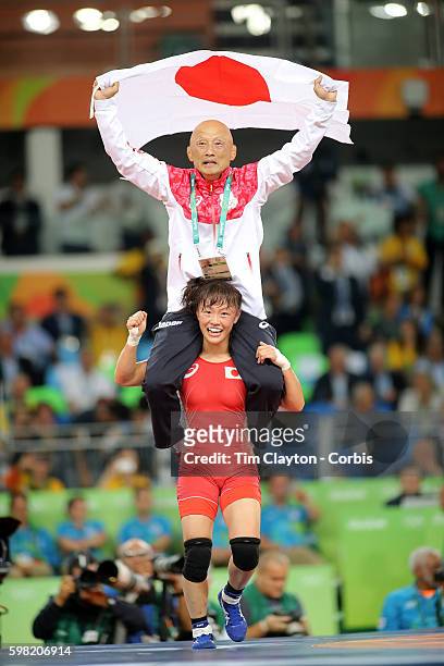 Day 12 Eri Tosaka of Japan celebrates her dramatic last minute victory against Mariya Stadnik of Azerbaijan carrying coach Kazuhito Sakae around the...