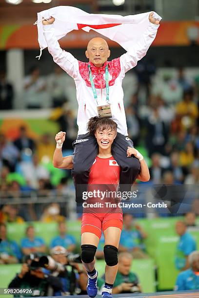 Day 12 Eri Tosaka of Japan celebrates her dramatic last minute victory against Mariya Stadnik of Azerbaijan carrying coach Kazuhito Sakae around the...