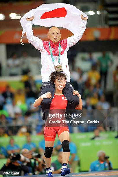 Day 12 Eri Tosaka of Japan celebrates her dramatic last minute victory against Mariya Stadnik of Azerbaijan carrying coach Kazuhito Sakae around the...