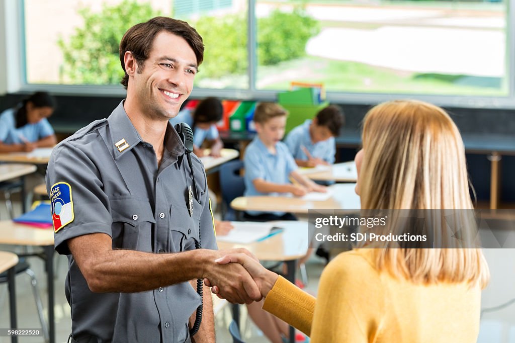 Security professional greets school teacher in classroom