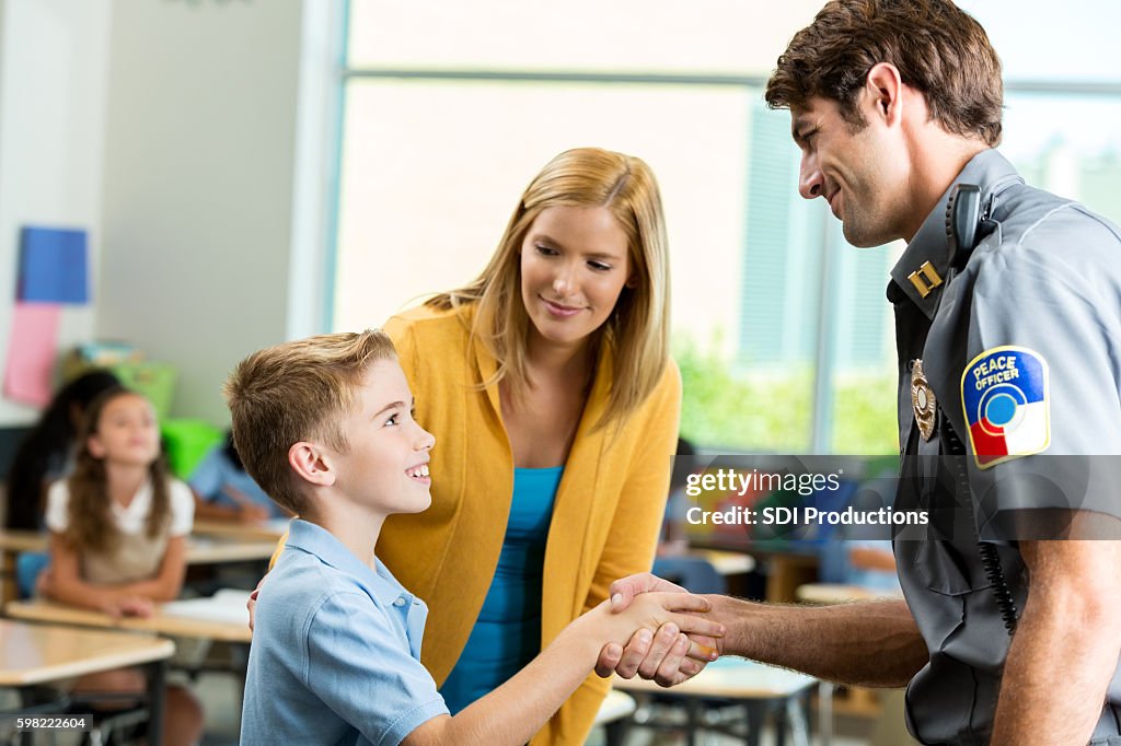 Security guard greets elementary student in classroom