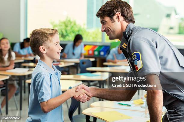 security officer greets elementary age private school student - school officer stock pictures, royalty-free photos & images