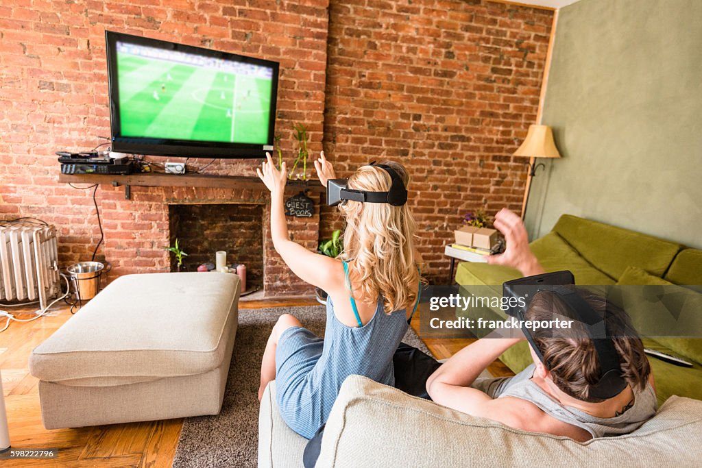 Couple using the VR simulator at home on the sofa