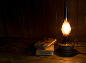 Old antique books with burning paraffin lamp.