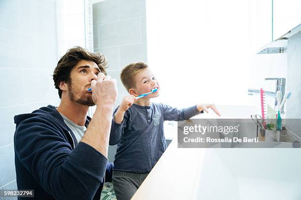 father and son brushing their teeth - tooth bonding stock pictures, royalty-free photos & images