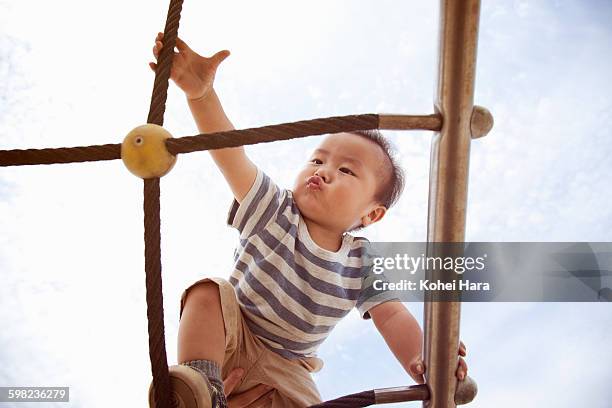 an asian baby boy walking tightropes - confronting challenges stock pictures, royalty-free photos & images