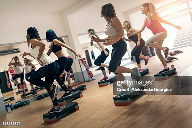 group of women at aerobics class exercising in gym - stappen stockfoto's en -beelden