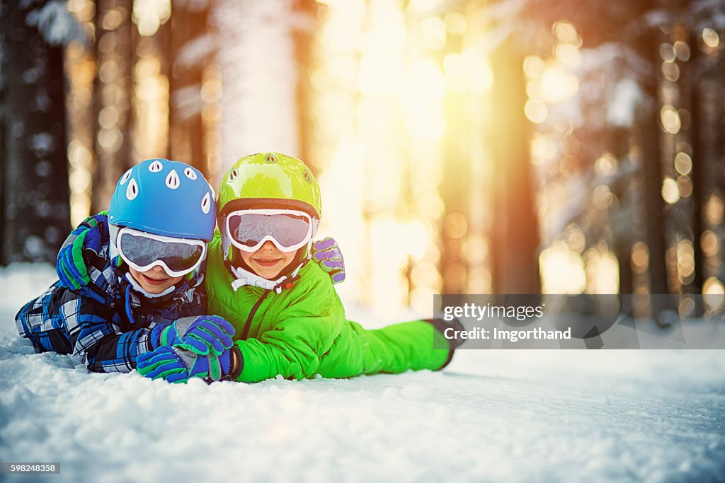 Happy boys in ski outfits enjoying winter