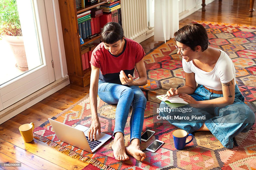 Two young women relaxing at home enjoying free time