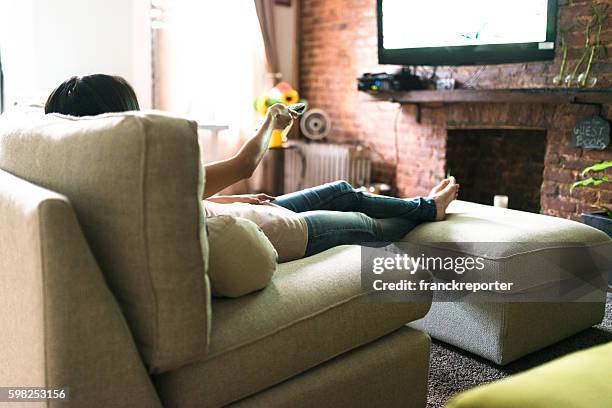 woman relaxing online on sofa reading some papers - feet up tv stock pictures, royalty-free photos & images