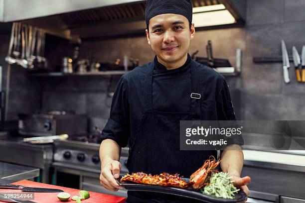 chef holding prepared meal. - philippines stock pictures, royalty-free photos & images