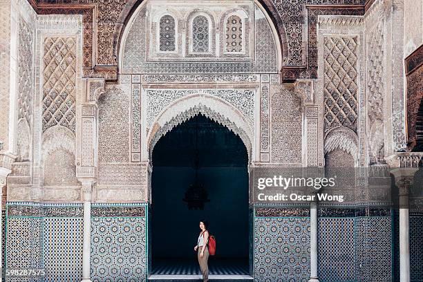 woman tourist visiting old temple in marrakech - marruecos stock-fotos und bilder