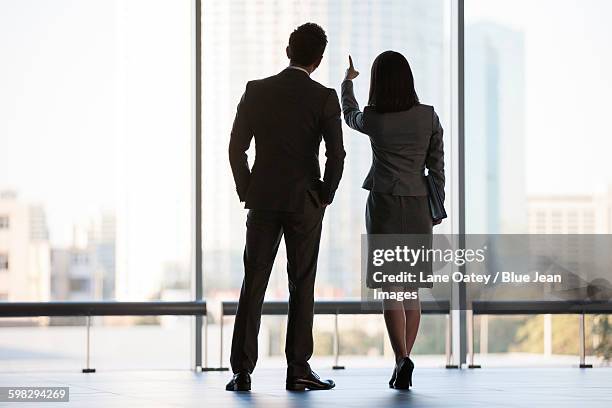 business person looking through window - 2 businessmen in silhouette stock pictures, royalty-free photos & images