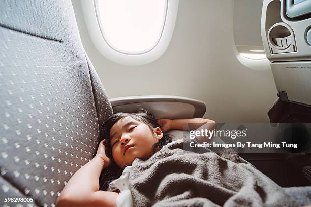 little girl sleeping soundly in the airplane - jet lag stockfoto's en -beelden
