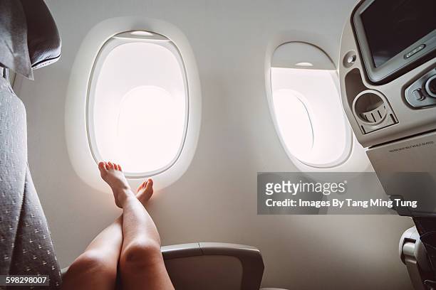 little girl relaxing in the airplane - barefoot stock pictures, royalty-free photos & images