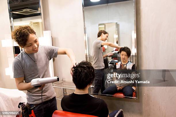 young hairdresser blowing hair - atsushi yamada stock pictures, royalty-free photos & images