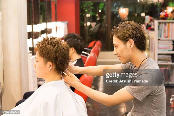 young hairdresser cutting hair - atsushi yamada stock pictures, royalty-free photos & images