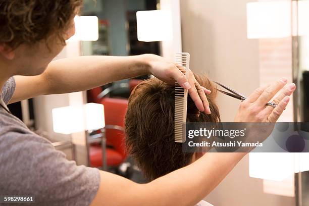 young hairdresser cutting hair - atsushi yamada stock pictures, royalty-free photos & images