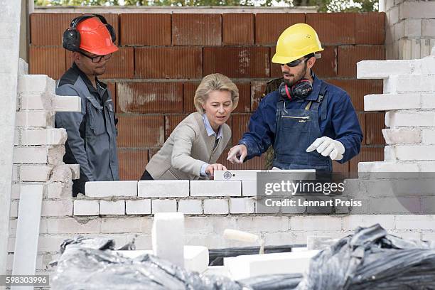 German Defense Minister Ursula von der Leyen speaks with a Syrian refugee who has found asylum in Germany and an instructor of the German army...