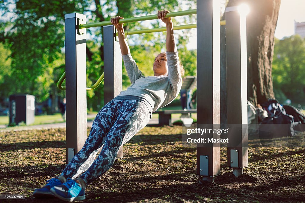 Low angle view of woman exercising on railing at park