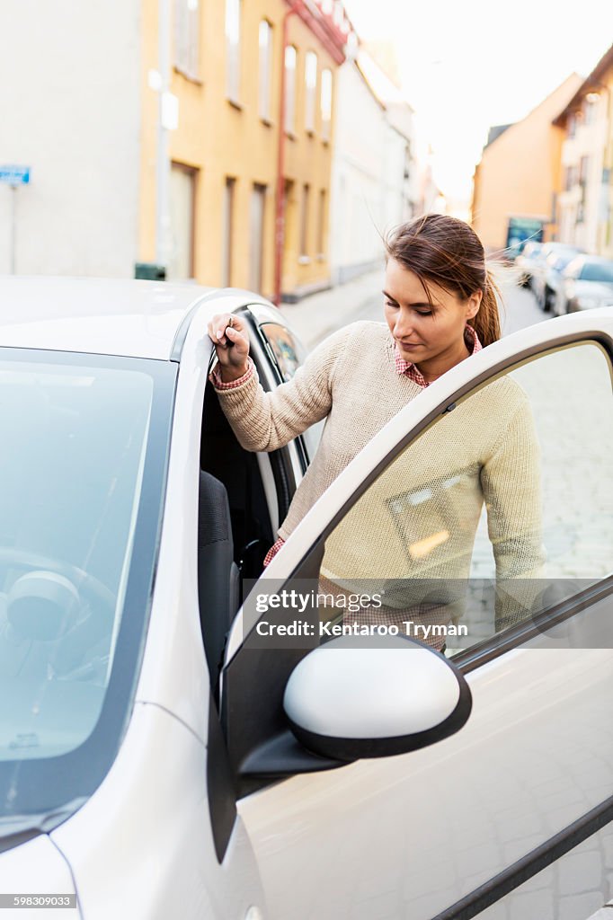 Businesswoman entering car on street