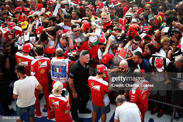 Sebastian Vettel of Germany and Ferrari and Kimi Raikkonen of Finland and Ferrari sign autographs for fans in the Pitlane during previews for the...