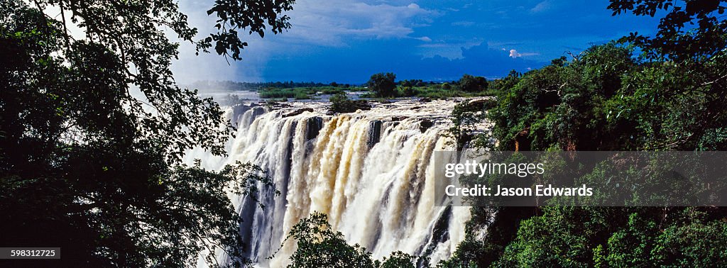 The view of Victoria Falls through a rainforest canopy as it plunges into the cataract.