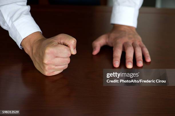 businessman pounding fist on table, cropped - balle stock-fotos und bilder