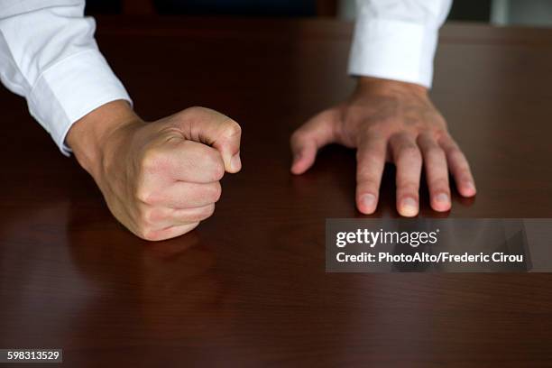 businessman pounding fist on table, cropped - clenched fist stockfoto's en -beelden