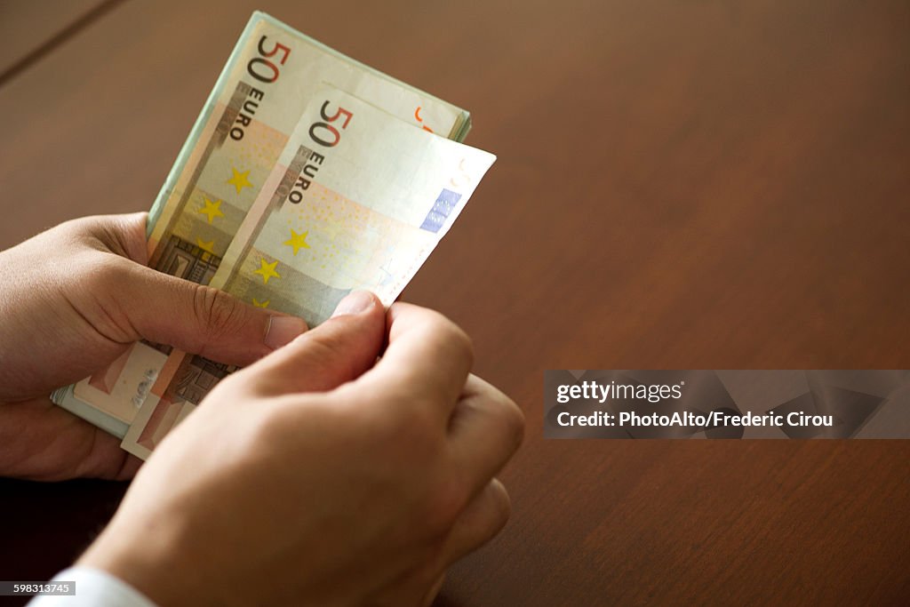 Hands counting fifty euro banknotes
