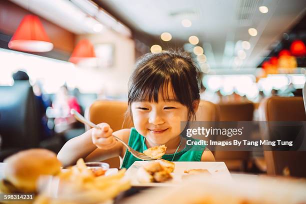 lovely little girl having meals joyfully - young restaurant stock pictures, royalty-free photos & images