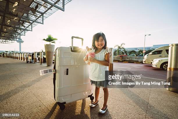 little girl with luggage smiling joyfully at hotel - singapore travel stock pictures, royalty-free photos & images