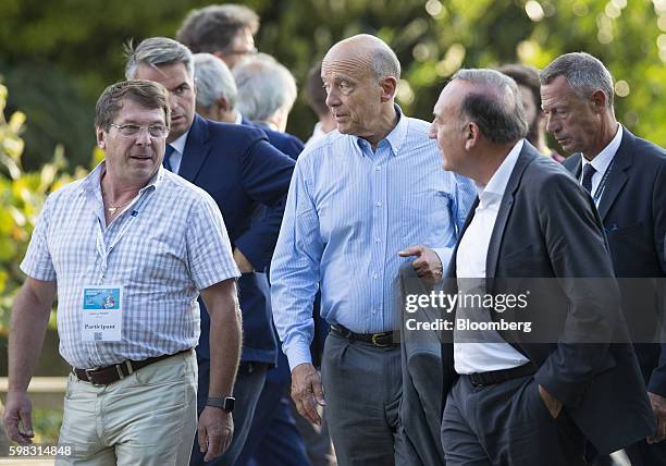 Alain Juppe, former French prime minister, center, leaves after attending the MEDEF business conference in Jouy-en-Josas, France, on Wednesday, Aug....