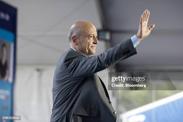 Alain Juppe, former French prime minister, waves to the audience during the MEDEF business conference in Jouy-en-Josas, France, on Wednesday, Aug....