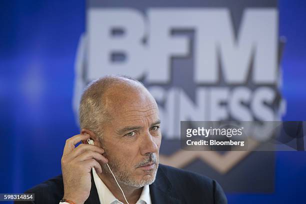 Stephane Richard, chief executive officer of Orange SA, adjusts an earpiece during a panel session at the MEDEF business conference in Jouy-en-Josas,...