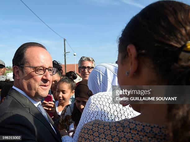 French President Francois Hollande speaks with a woman as he leaves the secondary school Jean Rostand after his visit for the first day of the...