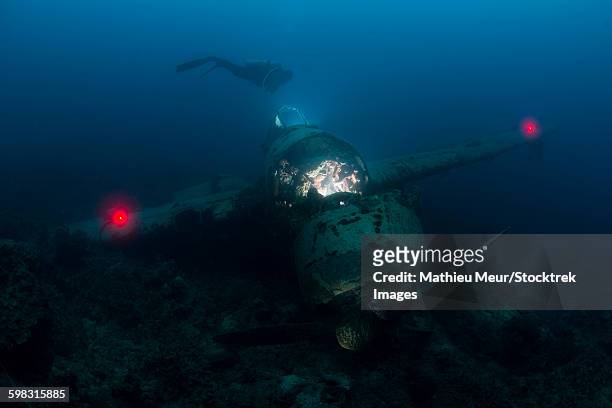diver exploring the wreck of a japanese navy seaplane in palau, micronesia. - air crash investigation stock pictures, royalty-free photos & images