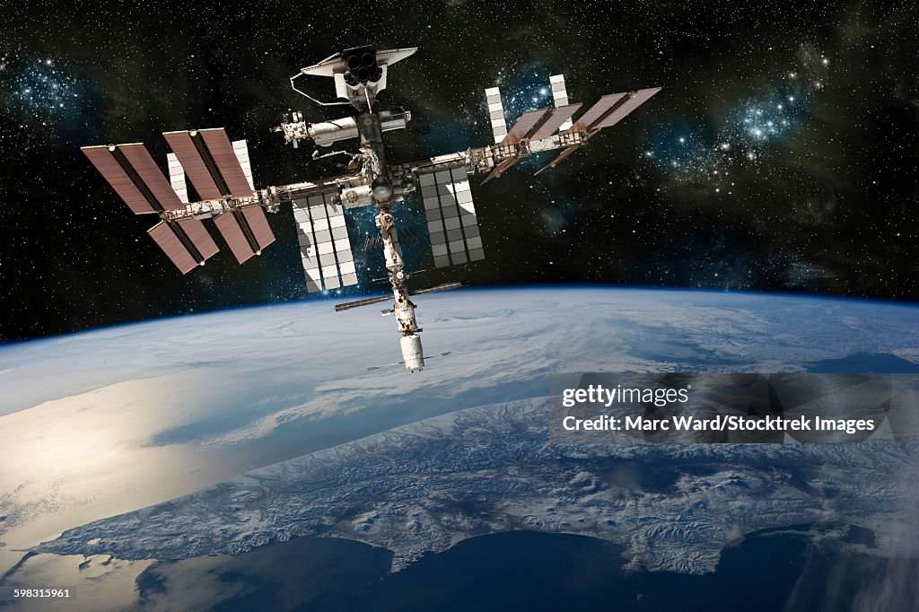 A depiction of the space shuttle docked at the International Space Station orbiting Earth.