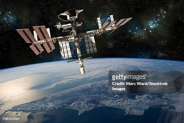 a depiction of the space shuttle docked at the international space station orbiting earth. - estación espacial internacional fotografías e imágenes de stock
