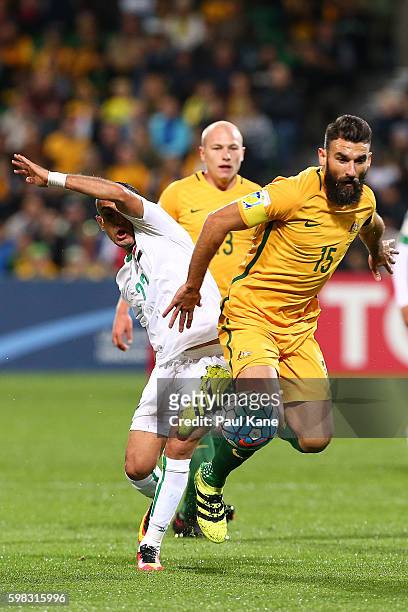 Ali Abbas of Iraqand Mile Jedinak of Australia contest for the ball during the 2018 FIFA World Cup Qualifier match between the Australian Socceroos...