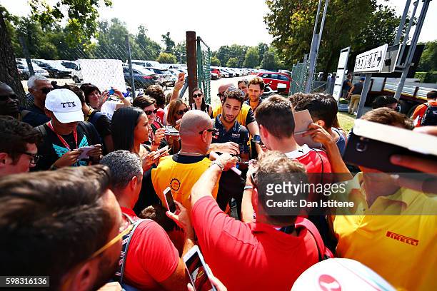 Daniel Ricciardo of Australia and Red Bull Racing is swamped by fans as he arrives at the circuit during previews for the Formula One Grand Prix of...