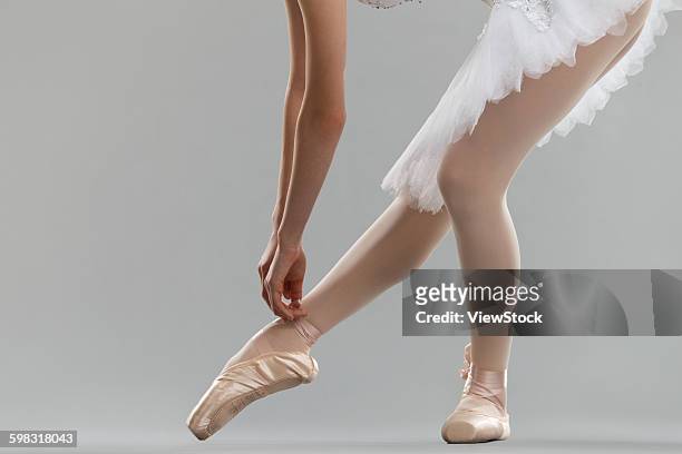 young woman is a ballet shoe lace - bending over in skirt stock-fotos und bilder