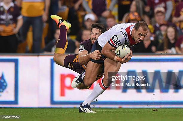 Blake Ferguson of the Roosters is tackled by Ben Hunt of the Broncos during the round 26 NRL match between the Brisbane Broncos and the Sydney...