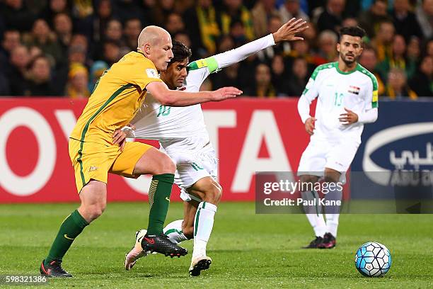 Aaron Mooy of Australia and Alaa Abdulzehra of Iraq contest for the ball during the 2018 FIFA World Cup Qualifier match between the Australian...