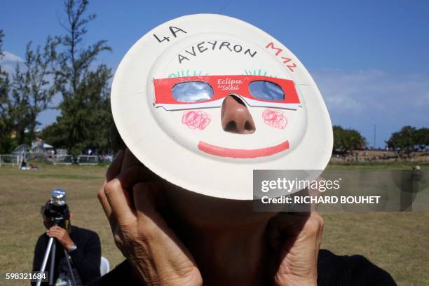 Woman looks through eclipse viewing glasses an annular solar eclipse, on September 1 in Saint-Louis, on the Indian Ocean island of La Reunion....