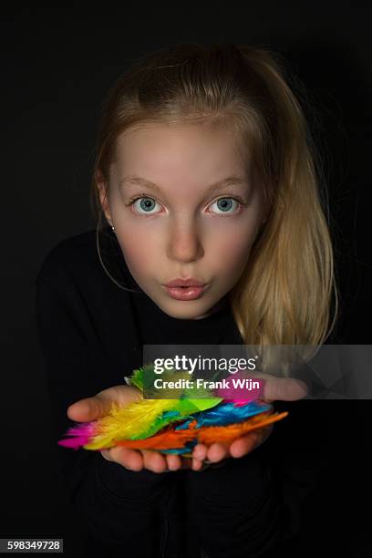 girl blowing colorful feathers in hands - wijn stock pictures, royalty-free photos & images