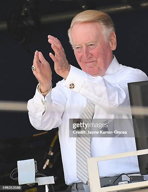 Los Angeles Dodgers broadcaster Vin Scully acknowledges the umpired crew before the start of the game against the Chicago Cubs at Dodger Stadium on...