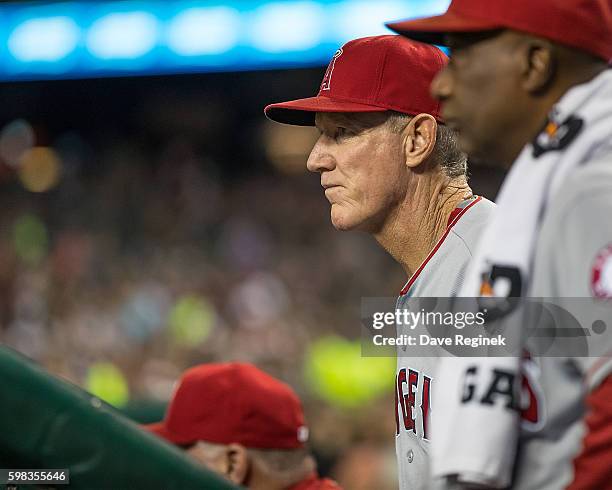 Third Base Coach Ron Roenicke of the Los Angeles Angels watches the action from the dugout during a MLB game against the Detroit Tigers at Comerica...