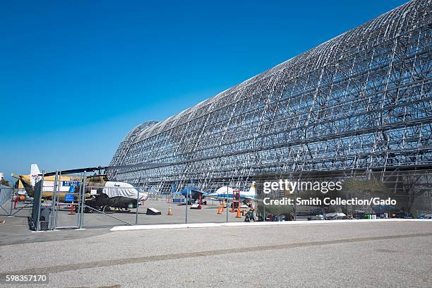 Metal structure of Hangar One, with historical aircraft displayed in the foreground, within the secure area of the NASA Ames Research Center campus...
