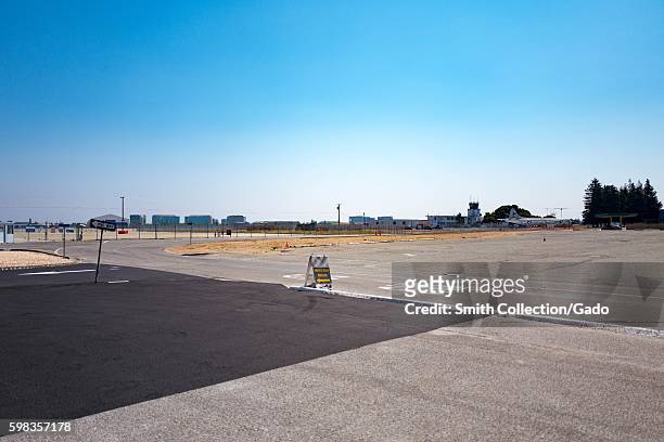 Planes and control tower viewed across access road leading to Moffett Field, within the secure area of the NASA Ames Research Center campus in the...